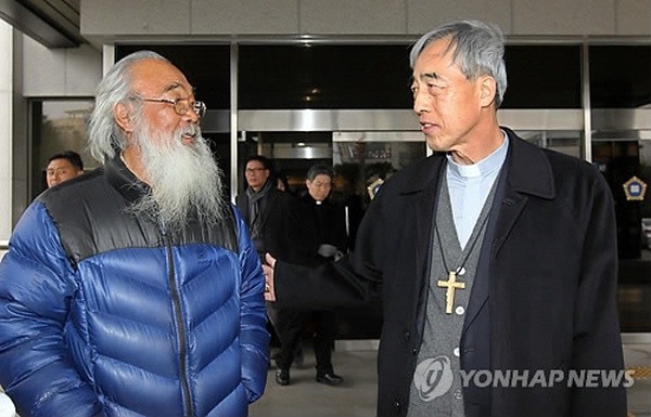 ▲ 한국천주교주교회의 의장인 강우일(우측) 주교가 지난달 24일 오전 제주지방법원 202호 법정에 들어가 제주해군기지 반대 운동을 하다 기소된 신부와 성직자들의 선고 공판 과정을 지켜보고 나온 뒤 문정현 신부를 격려하고 있다.  ⓒ 연합뉴스