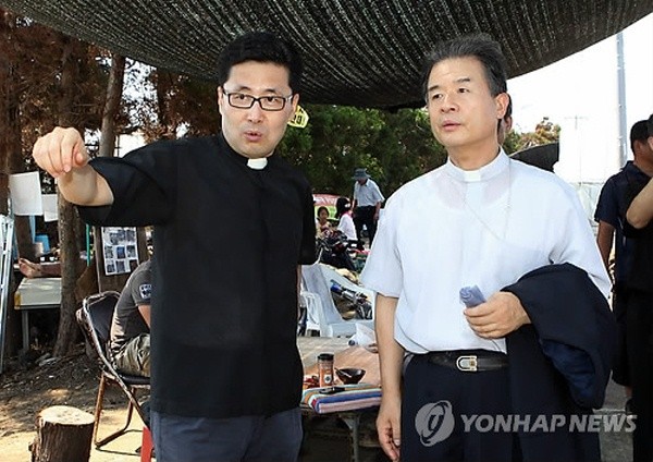 ▲ 천주교 주교회의 정의평화위원회 이용훈(우측) 위원장이 지난해 제주도 서귀포시 강정마을 말질사거리에서 해군기지 건설 중단을 촉구하는 기자회견을 한 뒤 중덕삼거리를 찾아 제주교구 고병수 신부로부터 설명을 듣고 있다. 이용훈 위원장은 수원교구장을 맡고 있다.  ⓒ 연합뉴스