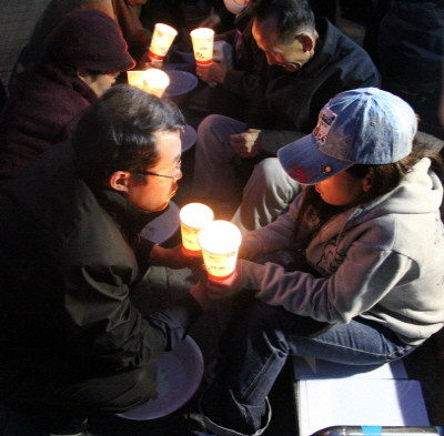 ▲ 북한정의연대 대표 정베드로 목사가 한 탈북여성의 손을 잡고 기도하고 있다. ⓒ 뉴데일리
