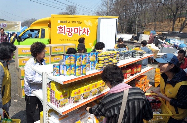 ▲ 17일 오후 이마트 임직원 등 70여명이 서초구 전원마을 비닐하우스촌을 찾아 80여개 가구에 라면, 고추장, 쌀 등 생필품을 ‘희망마차’에서 직접 꺼내 주민들에게 전달하는 봉사활동을 펼치고 있다.