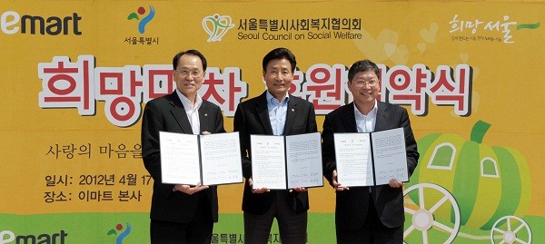 ▲ 이마트가 서울시와 손잡고 희망마차를 후원하는 협약식을 서울 성수동 이마트 사옥 광장에서 연 가운데 참석자들이 협약서를 들고 기념촬영을 하고 있다. 왼쪽부터 황용규 서울시 사회복지협의회장, 최병렬 이마트 대표, 김경호 서울시 복지건강실장