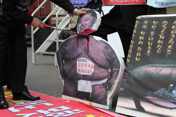 ▲ 북한인민해방전선의 한 회원이 북한 김정은 모형의 목을 낫으로 베는 퍼포먼스를 선보이고 있다. ⓒ 뉴데일리