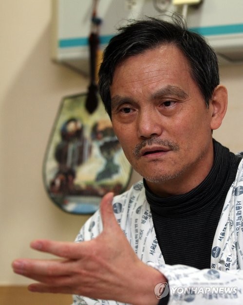 ▲ 폭력조직 '범서방파' 두목 김태촌씨가 지난 1월 서울 연건동 서울대병원에서 취재진에게 자신의 입장을 밝히고 있다. 김씨는 이번에 입원하기 전 한 중견기업인의 부탁을 받고 모 기업 대표에게 사업 투자금 25억원을 되돌려줄 것을 요구하며 수차례 협박한 혐의로 대구지방경찰청의 수사를 받아왔다. 사진=연합뉴스