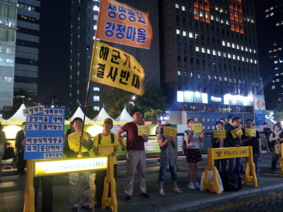 ▲ 집회에 참석한 일부 시민들이 한쪽에서 '해군기지 결사반대' 등이 적힌 팻말을 들고 있다. ⓒ 뉴데일리