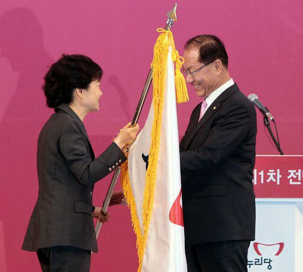 ▲ 15일 오후 경기도 고양시 일산 킨텍스 에서 열린 새 당대표와 최고위원 선출을 위한 새누리당 제1차 전당대회에서 당대표로 선출된 황우여 신임대표가 박근혜 비대위원장(왼쪽)에게 당기를 전달받고 있다. ⓒ연합뉴스