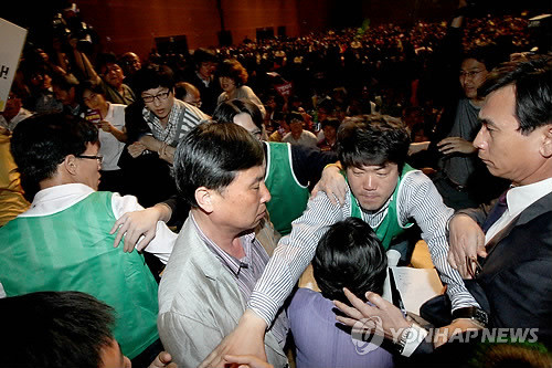 ▲ 통합진보당 중앙위원회 심상정 의장이 12일 고양시 킨텍스에서 열린 제1차 중앙위원회의에서 강령개정을 통과시키고 나서 단상에 난입한 중앙위원과 당원들의 공격을 받자 유시민 조준호 공동대표와 행사진행요원이 에워싸고 있다. ⓒ연합뉴스