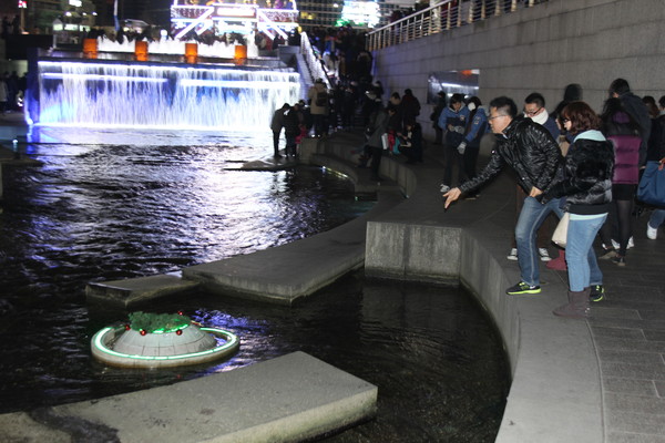 ▲ 청계천 팔석담 폭포 앞에서 행운의 동전을 던지는 시민들.ⓒ