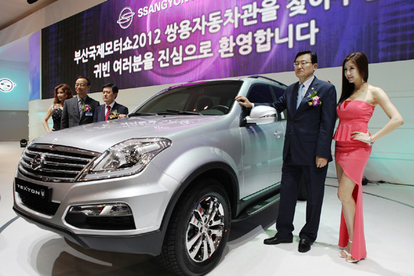 ▲ 쌍용차의 '렉스턴 W' 옆에서 포즈를 취하는 홍석우 지경부 장관(오른쪽).