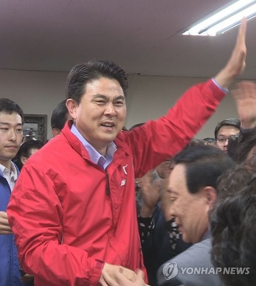 ▲ 새누리당 김태호 의원이 민주통합당 김경수 후보와 접전을 벌인 끝에 당선이 확정되자 손을 번쩍 들어 지지자들에게 인사하며 기뻐하고 있다. 2012.4.12. ⓒ 연합뉴스