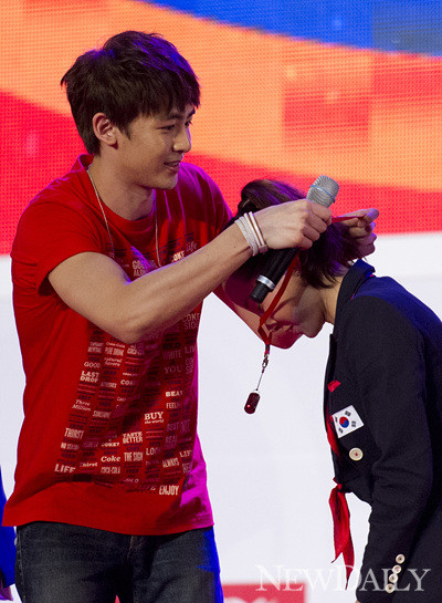 ▲ 2pm 닉쿤이 남현희 선수에게 금메달 기원이 담신 선물을 전달하고 있다ⓒ양호상기자