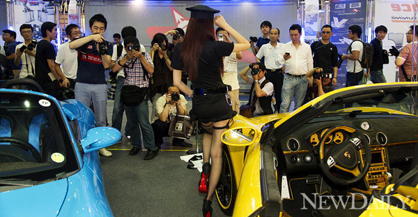 ▲ '2012 서울오토살롱' 플랜비 모터스 부스에서 레이싱모델 민시아가 포즈를 취하자 관람객들이 사진을 찍고 있다ⓒ양호상기자