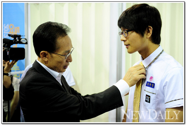 ▲ 이명박 대통령이 18일 서울 대치동에서 열린 2012 열린 고용 채용박람회에서 한 고등학생의 넥타이를 매주고 있다. ⓒ 뉴데일리