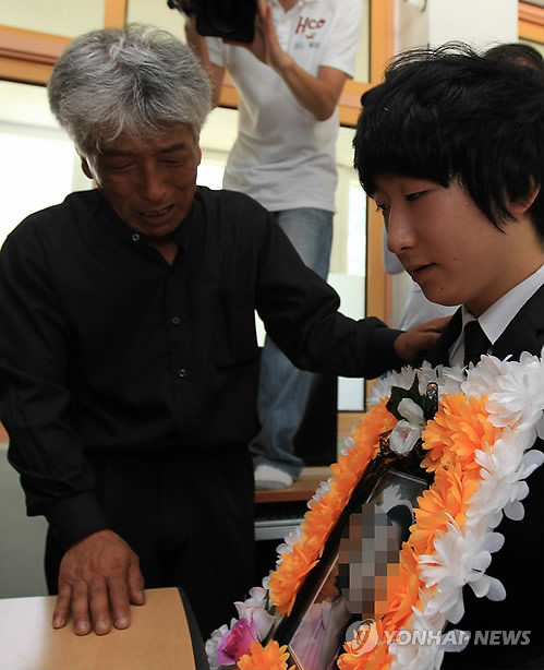 ▲ 실종 일주일만에 숨진 채 발견된 경남 통영 한모(10)양의 아버지와 오빠가 25일 한 양의 영정을 들고 학교 책상에 앉아 슬퍼하고 있다. ⓒ연합뉴스