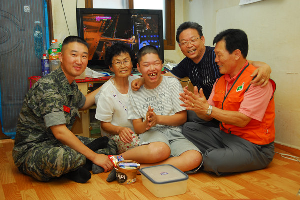 ▲ 한 장애인의 집을 찾은 이찬우 대위와 봉사단체 회원들