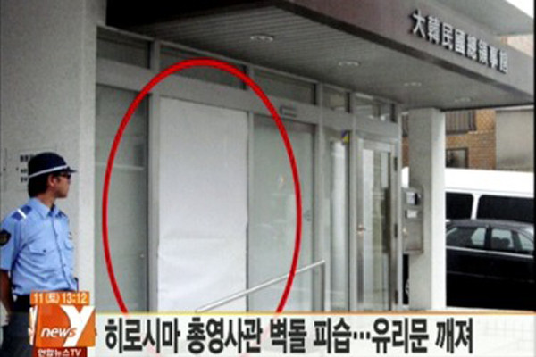 ▲ 연합뉴스TV가 전한 히로시마 총영사관 현관 유리문의 모습. 벽돌로 깨진 곳을 임시로 막아놨다.[사진. 연합TV 화면캡쳐]