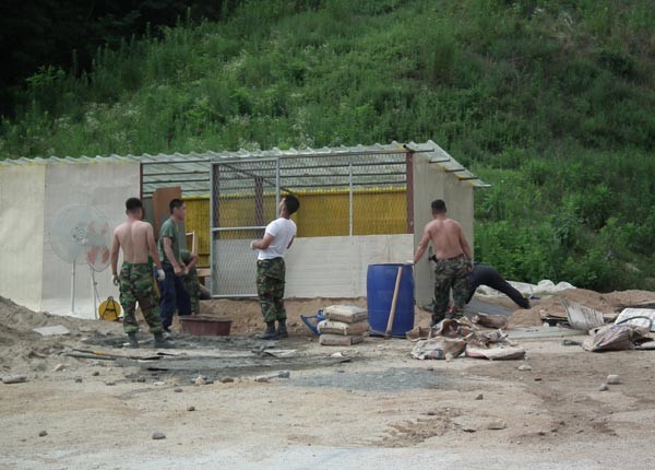 ▲ 30도가 넘는 불볕더위 아래서 '삽질' 중인 장병들. 저들 중 네 명이 '간부'다. 병사들은 쉬고 있었다.