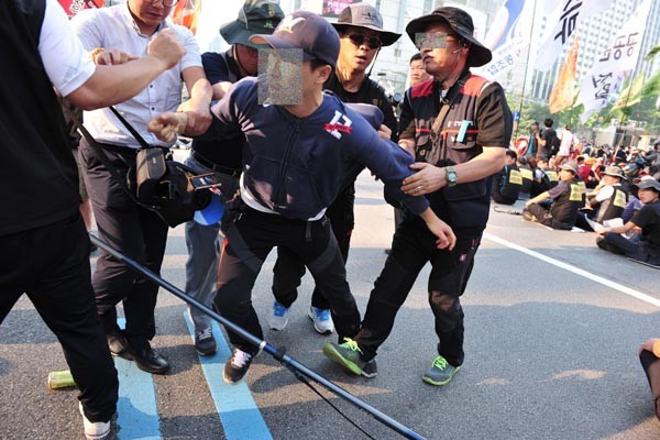 ▲ 한 경찰이 시위대에 붙잡혀 카메라와 메모리카드를 빼앗겼다.