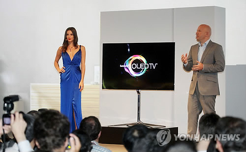 ▲ 독일베를린 'IFA 2012' 개막을 하루 앞둔 지난달 30일 삼성전자 유럽 마케팅 디렉터 마이클 졸러가 패션모델 안젤라 벨로트와 함께 삼성 OLED TV를 소개하고 있는 모습(자료사진)