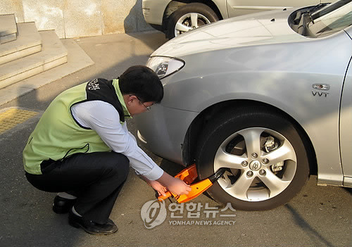 ▲ 체납자 소유 차량에 족쇄를 채우는 모습(자료사진).ⓒ 연합뉴스