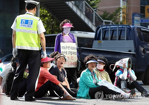 ▲ 저축은행 피해자들과 전국언론노조 부산일보지부 및 정수재단반환부산시민연대 회원들이 24일 오후 부산 수영구 남천동 부산시당 앞 도로에 주저앉아 새누리당 박근혜 후보 사과발언에 대한 집회를 열고 있다. ⓒ 연합뉴스