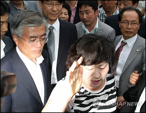 ▲ 문재인 민주통합당 상임고문이 자신의 지역구인 부산 사상구 덕포시장에서 김옥주 부산저축은행 비상대책위원장의 항의를 받고 있다. ⓒ 연합뉴스(자료사진) 2012.6.29
