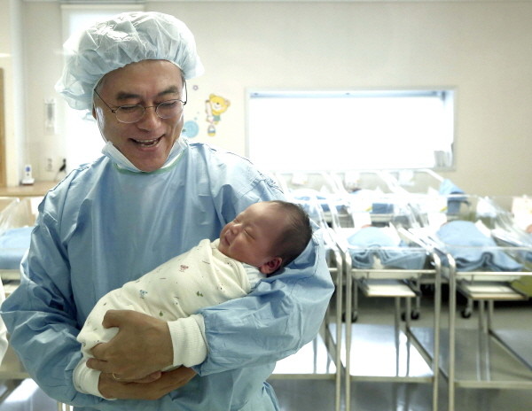 ▲ 산부인과 신생아실에서 생후 2일된 아기를 안고 사진을 찍고 있는 문재인 후보 ⓒ 민주당 제공