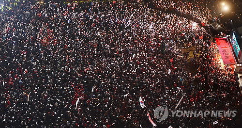 ▲ 제18대 대통령선거를 하루 앞둔 18일 오후 서울 광화문 광장에서 열린 새누리당 집중유세에서 유권자들이 박근혜 대선후보의 유세를 보고 있다.  ⓒ 연합뉴스