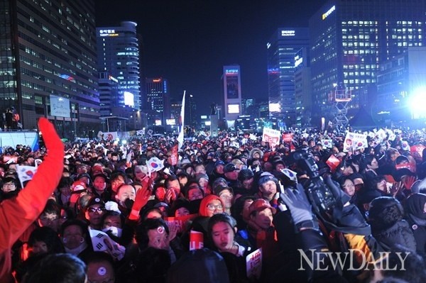 ▲ 제18대 대통령선거를 하루 앞둔 18일 오후 서울 광화문 광장에서 열린 새누리당 집중유세에서 유권자들이 박근혜 대선후보의 유세를 보고 있다.  ⓒ 연합뉴스