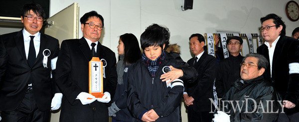 ▲ 8일 오전 발인식이 끝난 뒤 영정을 안고 운구차로 향하는 유가족·지인들의 모습. 오열을 하고 있는 홍원기(좌측) 넥센 코치와 위패를 들고 있는 고인의 전 에이전트 손덕기(좌측 두번째)씨의 모습이 보인다. 침울한 표정을 짓고 있는 환희군(가운데)과 아버지 조주형(우측)씨의 모습이 안쓰럽다.   ⓒ 이종현 기자