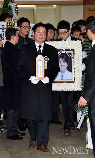 ▲ 지난 8일 고인의 발인식이 끝난 뒤 위패를 안고 빈소를 나오는 손덕기(가운데)씨의 모습.  ⓒ 이종현 기자