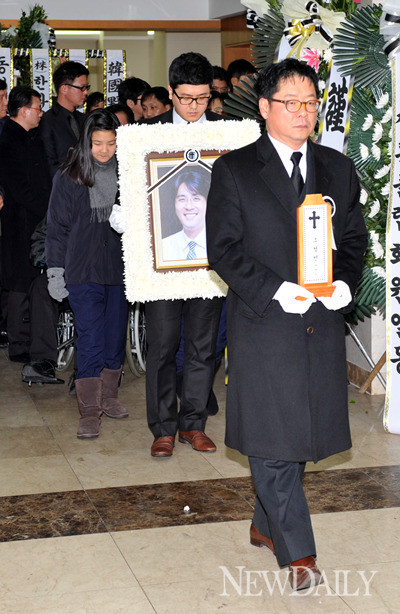 ▲ 지난 8일 고인의 발인식이 끝난 뒤 위패를 안고 빈소를 나오는 손덕기(가운데)씨의 모습.  ⓒ 이종현 기자