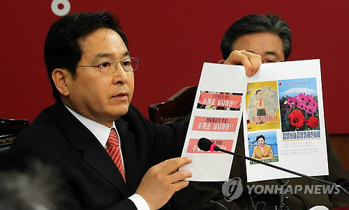 ▲ 새누리당 심재철 최고위원이 14일 오전 여의도 당사에서 열린 최고위원회의에서 대한문 앞 '대선 수개표' 요구 집회에 등장한 현수막 사진을 들어보이고 있다. ⓒ연합뉴스