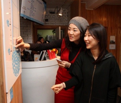 ▲ ⓒ‘사랑나눔 온도계’에 스티커를 붙이고 있는 조현민 상무와 행사 참가자.