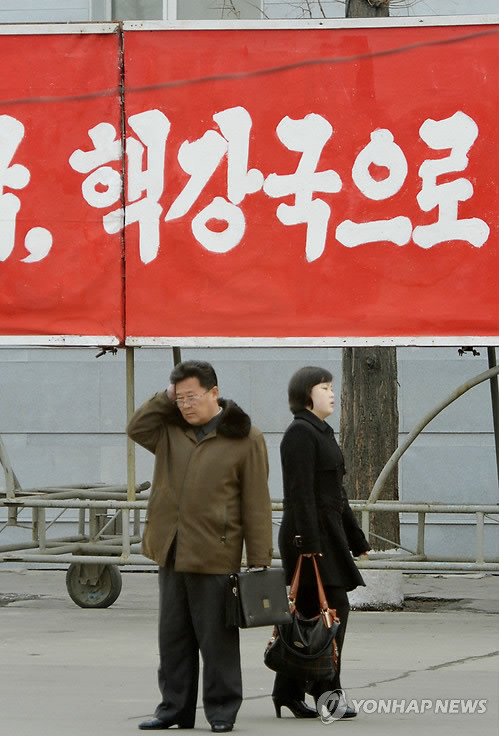 6일 오전 북한 평양 시내에 걸린 '핵강국으로'라고 적힌 현수막 앞을 평양 시민들이 지나가고 있다. ⓒ 연합뉴스