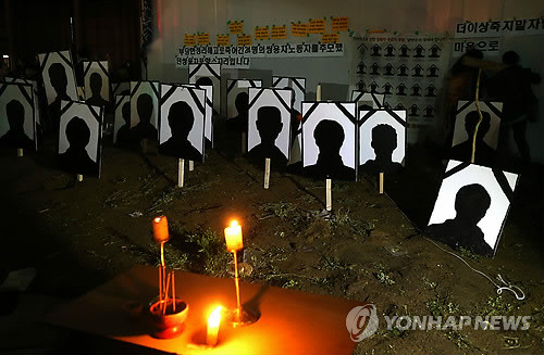 ▲ 4일 오후 10시, 천막 재설치를 막기 위해 중구청이 조성한 화단을 일시 점거한 농성대가 꽃과 나무를 뽑아내고 영정그림을 세워놓은 모습.ⓒ 연합뉴스