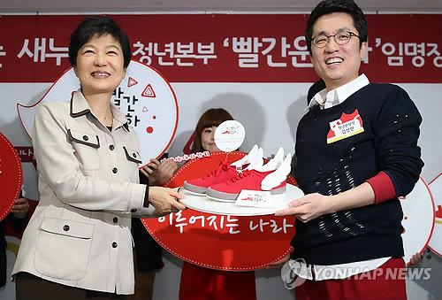 ▲ 새누리당 김상민 의원이 청년본부 출범식 및 임명장 수여식에서 박근혜 대통령에게 날개달린 빨간 운동화를 선물하는 모습. ⓒ연합뉴스