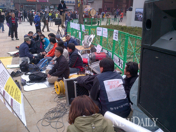▲ 4월 5일 오후, 쌍용차 농성대가 천막이 있던 화단 앞에 돗자리를 깔고 구청 및 경찰과 대치를 계속하고 있다.ⓒ 뉴데일리 윤희성 기자