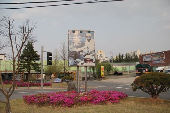 ▲ [박정희와 팝아트 투어] 행사에 참가한 한 여성이 박정희 전 대통령 생가 앞에 전시된 육영수 여사 실물 모형 옆에서 손가락 욕을 하고 있는 모습