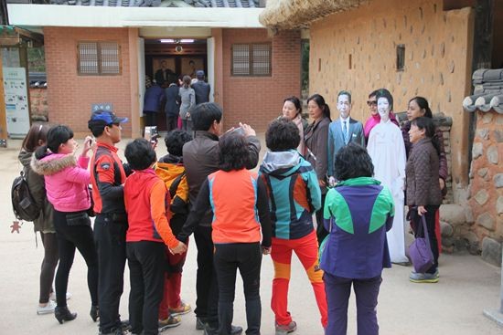 ▲ [박정희와 팝아트 투어] 행사에 참가한 한 여성이 박정희 전 대통령 생가 앞에 전시된 육영수 여사 실물 모형 옆에서 손가락 욕을 하고 있는 모습