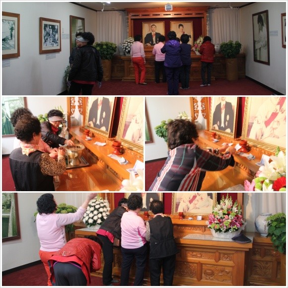 ▲ [박정희와 팝아트 투어] 행사에 참가한 한 여성이 박정희 전 대통령 생가 앞에 전시된 육영수 여사 실물 모형 옆에서 손가락 욕을 하고 있는 모습