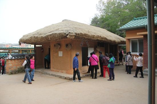 ▲ [박정희와 팝아트 투어] 행사에 참가한 한 여성이 박정희 전 대통령 생가 앞에 전시된 육영수 여사 실물 모형 옆에서 손가락 욕을 하고 있는 모습