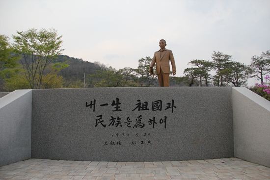 ▲ [박정희와 팝아트 투어] 행사에 참가한 한 여성이 박정희 전 대통령 생가 앞에 전시된 육영수 여사 실물 모형 옆에서 손가락 욕을 하고 있는 모습