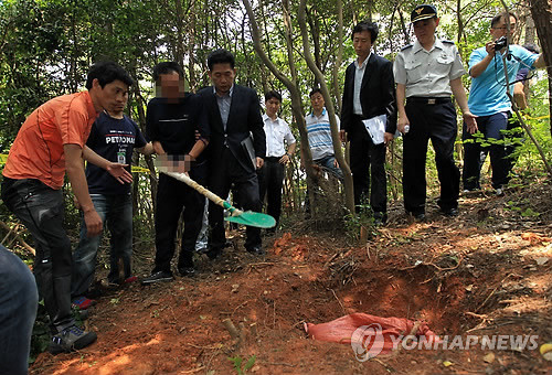 ▲ 지난해 7월 26일, 통영 초등생 살해사건의 범인 김점덕이 피해 학생의 시신을 유기한 상황을 재현하는 모습.ⓒ 연합뉴스