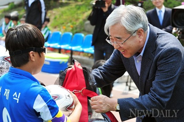 ▲ 문용린 교육감(오른쪽)이 지난 4일 열린 서울시교육감배 축구리그에서 초등학교 선수에게 공을 선물하고 있다.ⓒ이종현 기자
