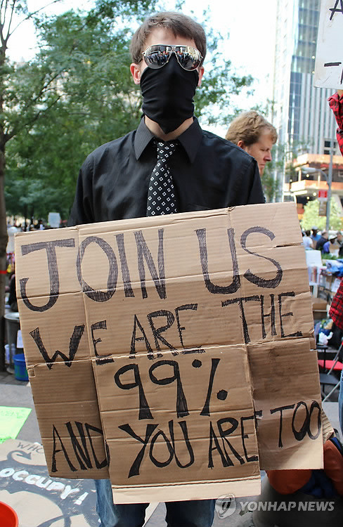 ▲ (뉴욕=연합뉴스) 2011년 10월 12일(현지시간) `월가를 점령하라(Occupy Wall Street)' 시위의 진원지인 뉴욕 맨해튼의 주코티 공원에서 한 시위자가 시위에 동참하라는 내용의 푯말을 들고 있다. 2011.10.13 ⓒ