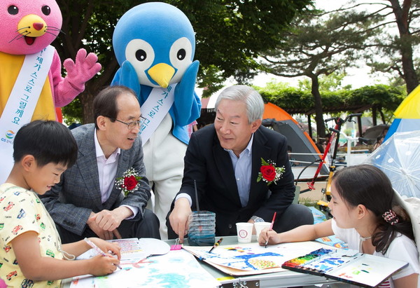 ▲ ⓒGS칼텍스 허진수 부회장(사진 우측)과 윤성규 환경부장관(사진 좌측)이 GS칼텍스 환경미술대회에 참가한 어린이들을 격려하는 모습.