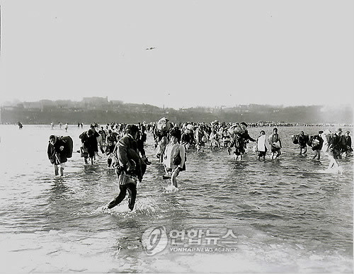 1950년 12월 3일. 중공군의 개입으로 엄동설한에 신발을 벗고 바지를 걷어올려 평양의 대동강을 건너 피난을 떠나는 북한 주민들.ⓒ 연합뉴스