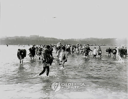 ▲ 1950년 12월 3일. 중공군의 개입으로 엄동설한에 신발을 벗고 바지를 걷어올려 평양의 대동강을 건너 피난을 떠나는 북한 주민들.ⓒ 연합뉴스