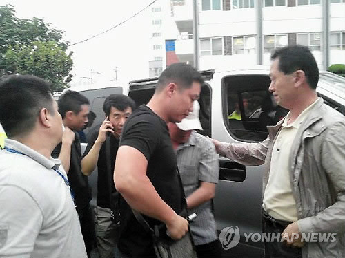 ▲ 14일 오후 부산 해운대구 해운대역 근처에서 붙잡혀 해운대경찰서로 압송되는 탈주범 이대우(베이지색 모자를 눌러쓴 사람).  ⓒ 연합뉴스