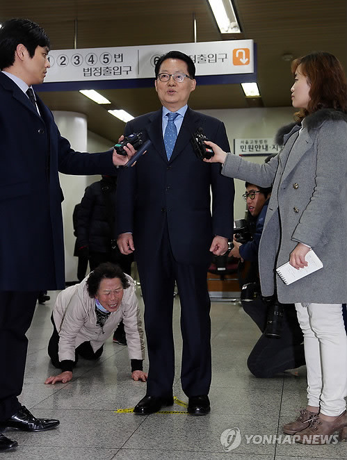 ▲ 저축은행에서 불법 자금을 받은 혐의로 기소된 민주당 박지원 의원이 지난 3월 20일 오후 서울 서초구 서초동 서울고등법원에서 열린 첫 공판에 출석하기 전 기자들의 질문에 대답하고 있다. 대답하는 박 전 원내대표 뒤로 한 저축은행 피해자가 항의하고 있다. ⓒ연합뉴스